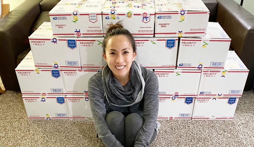 Becky sitting in front of boxes ready to be shipped.
